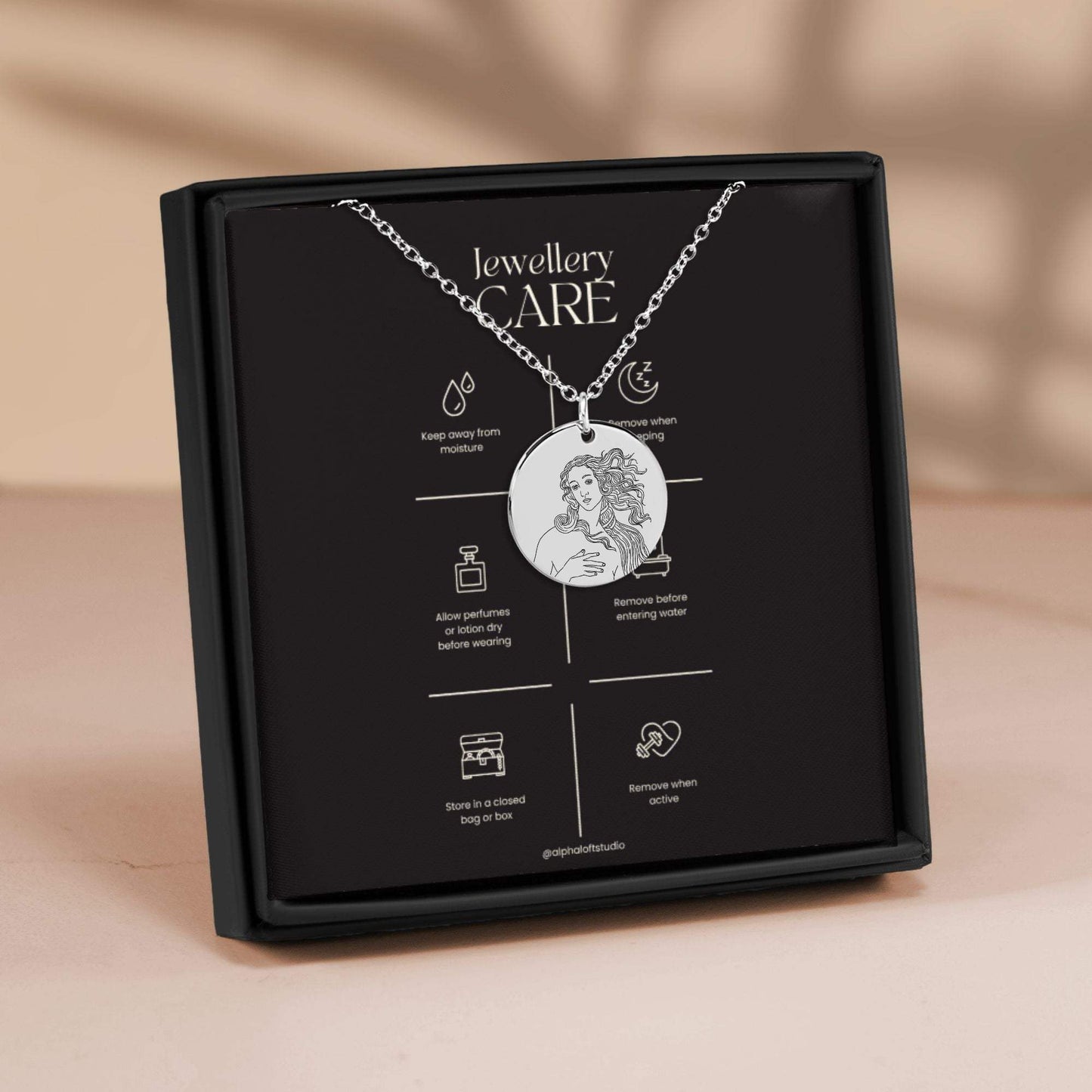 Aphrodite mythology necklace in packaging showing front engraved design