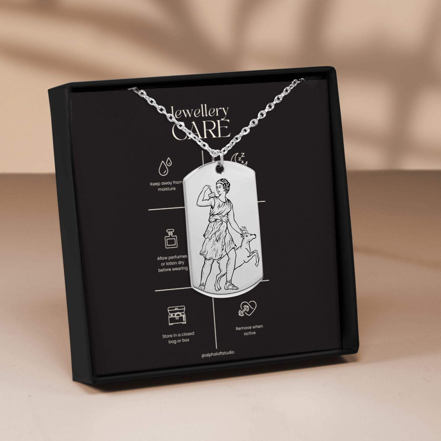 Artemis mythology necklace in packaging showing front and back engraved designs