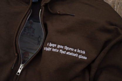 Flat lay of brown zip-up hoodie, silver full-zip hardware, drawstring hood, ribbed cuffs and hem, kangaroo pouch pockets, left-chest lyric embroidery -Noah Kahan The Great Divide inspired embroidered hoodie