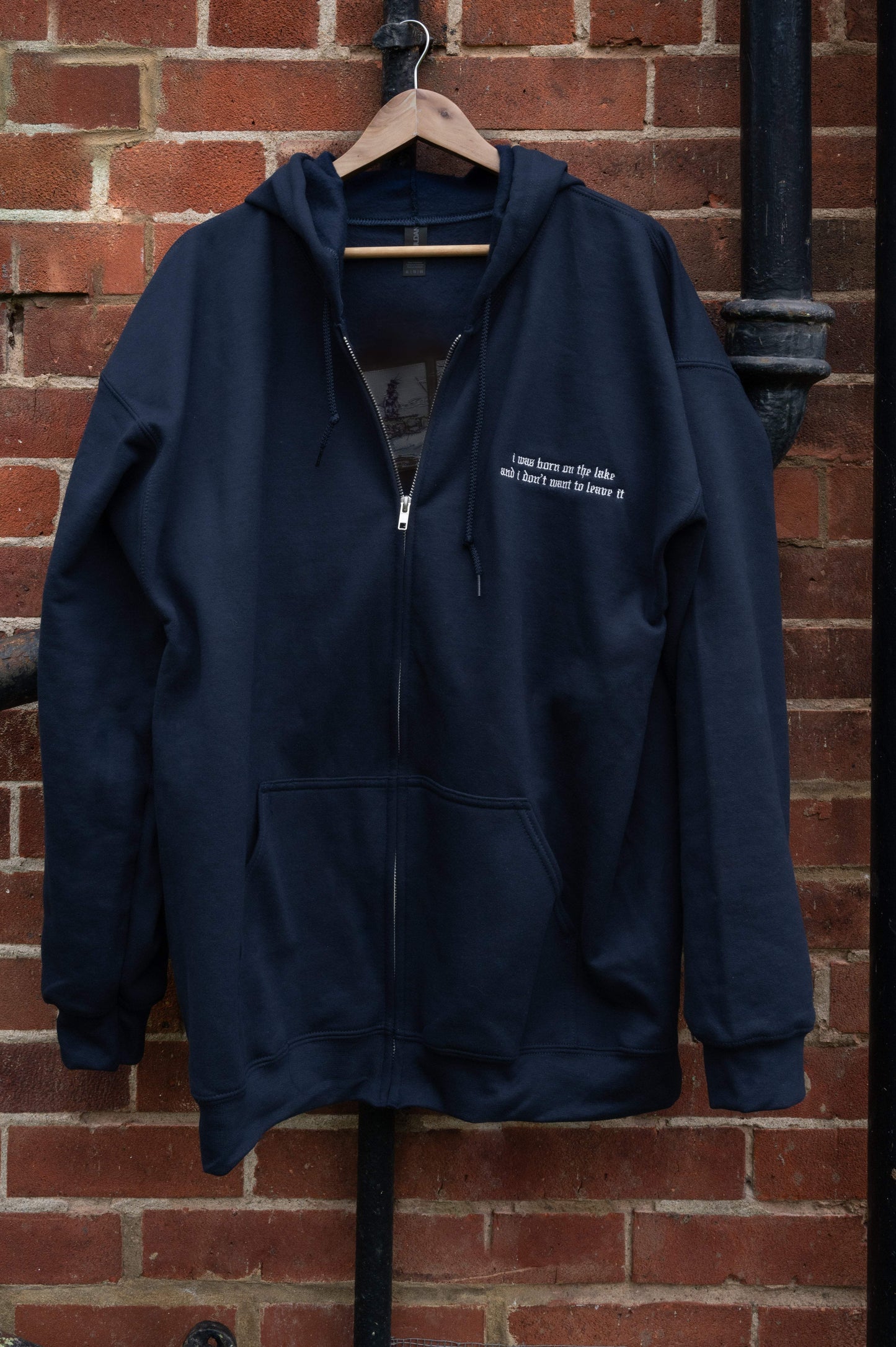 Navy fleece zip-up hoodie on a hanger, full-zip silver metal closure, drawstring hood, kangaroo pocket, small left-chest lyric embroidery - Lord Huron Lonesome Dreams inspired, unisex fit S–5XL

