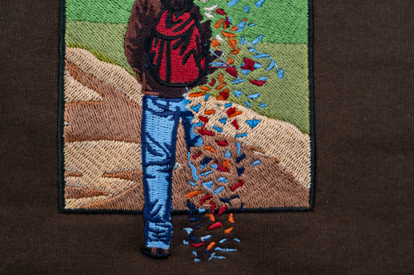 Embroidery closeup of The Great Divide stained glass design t-shirt in brown - noah kahan concert outfit 