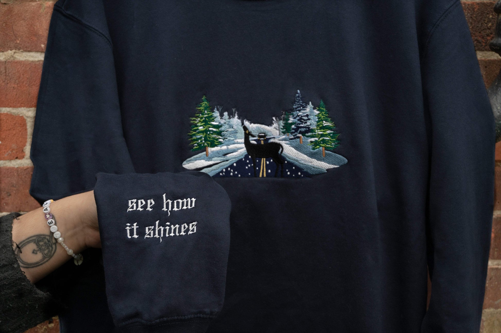 sleeve close up of abstract psychopomp embroidered sweatshirt  - Navy blue sweatshirt close up - See How It Shines hozier  
