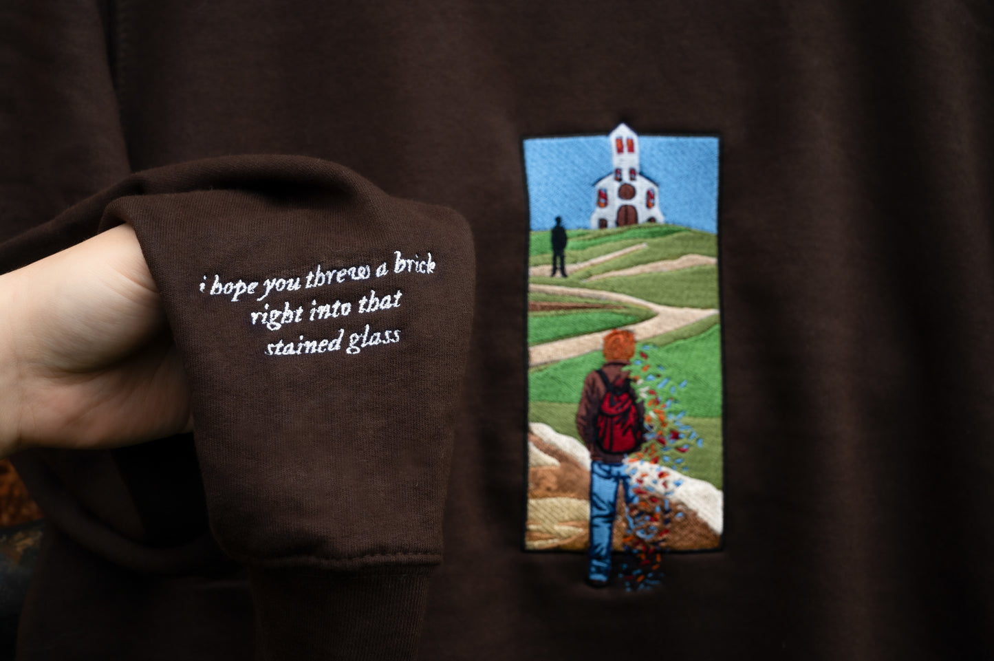 Sleeve detail closeup of The Great Divide stained glass design t-shirt in brown - noah kahan concert outfit 